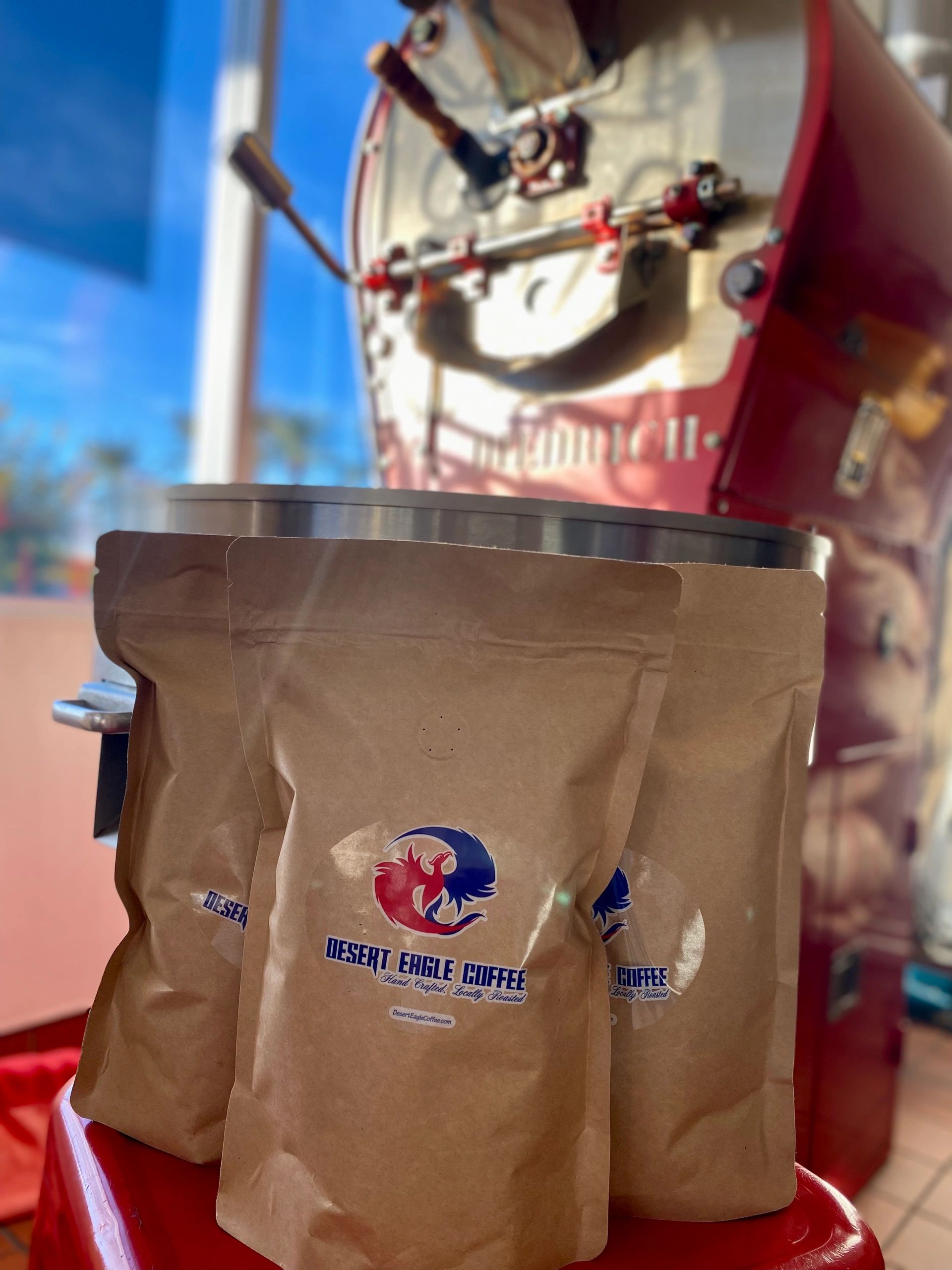 Bags of Desert Eagle Coffee beans beside the roaster